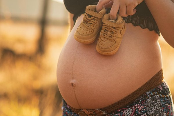 How can expectant mothers manage nausea and vomiting during the first trimester?